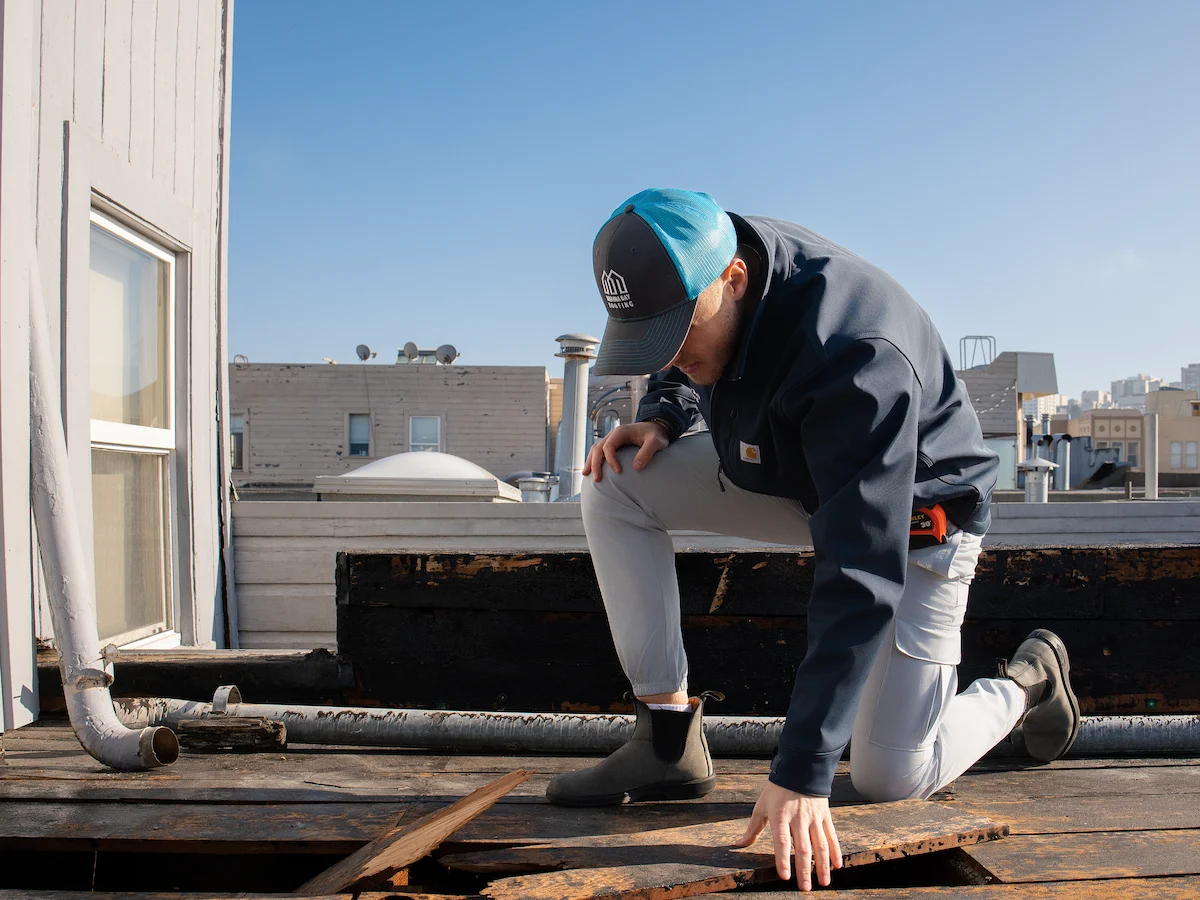 Marina Bay Roofing technician inspecting an exposed roof deck during an on-site evaluation