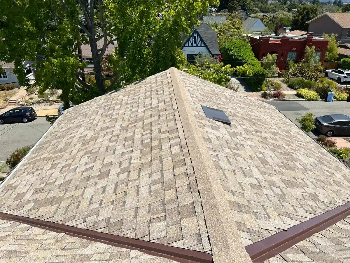 Aerial view of an aging asphalt shingle roof on a residential home in Marin County showing uneven granule coverage and signs of weathering across multiple slopes.