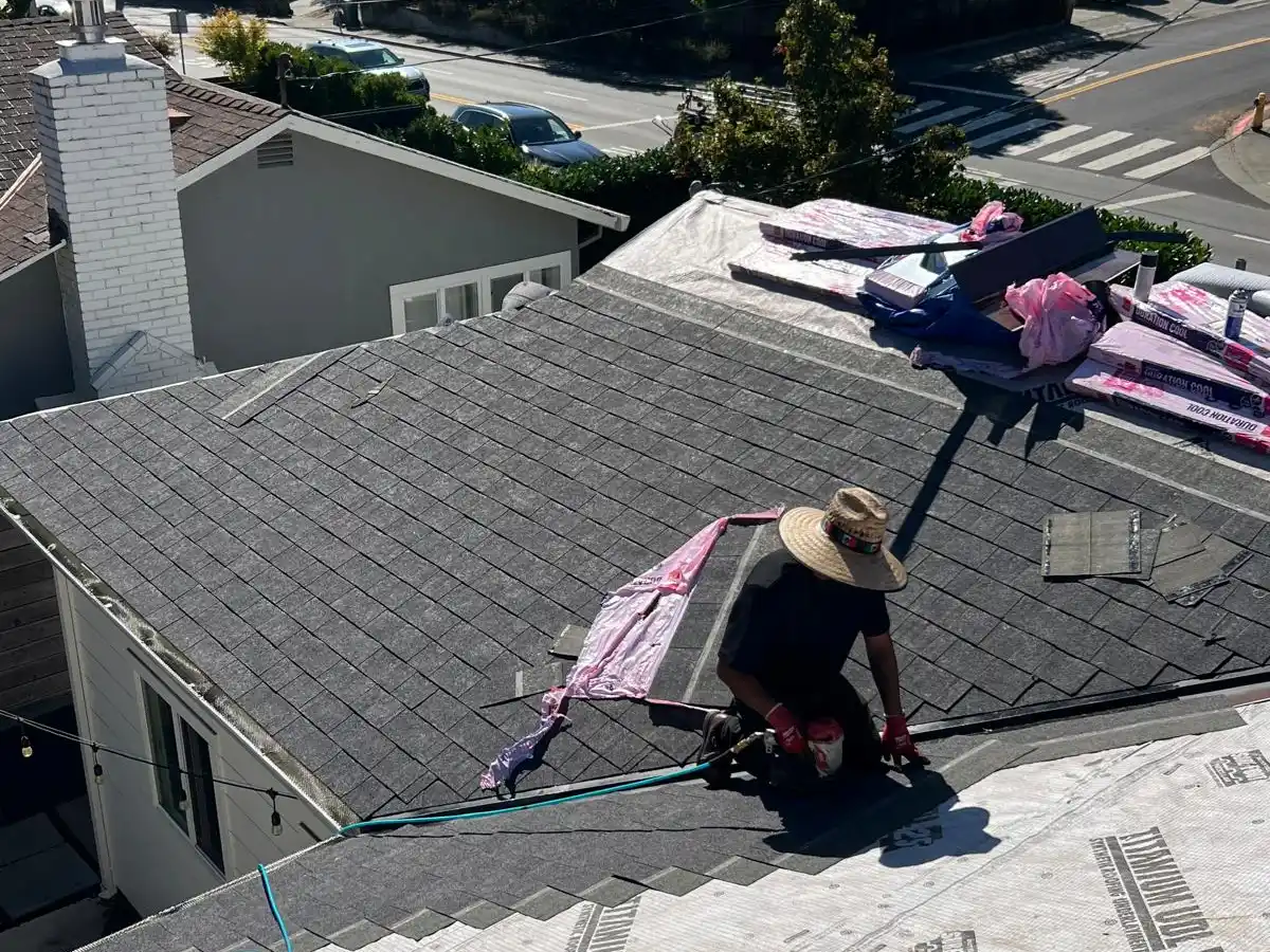 Roofing contractor installing insulation on a Marin County home's asphalt shingle roof